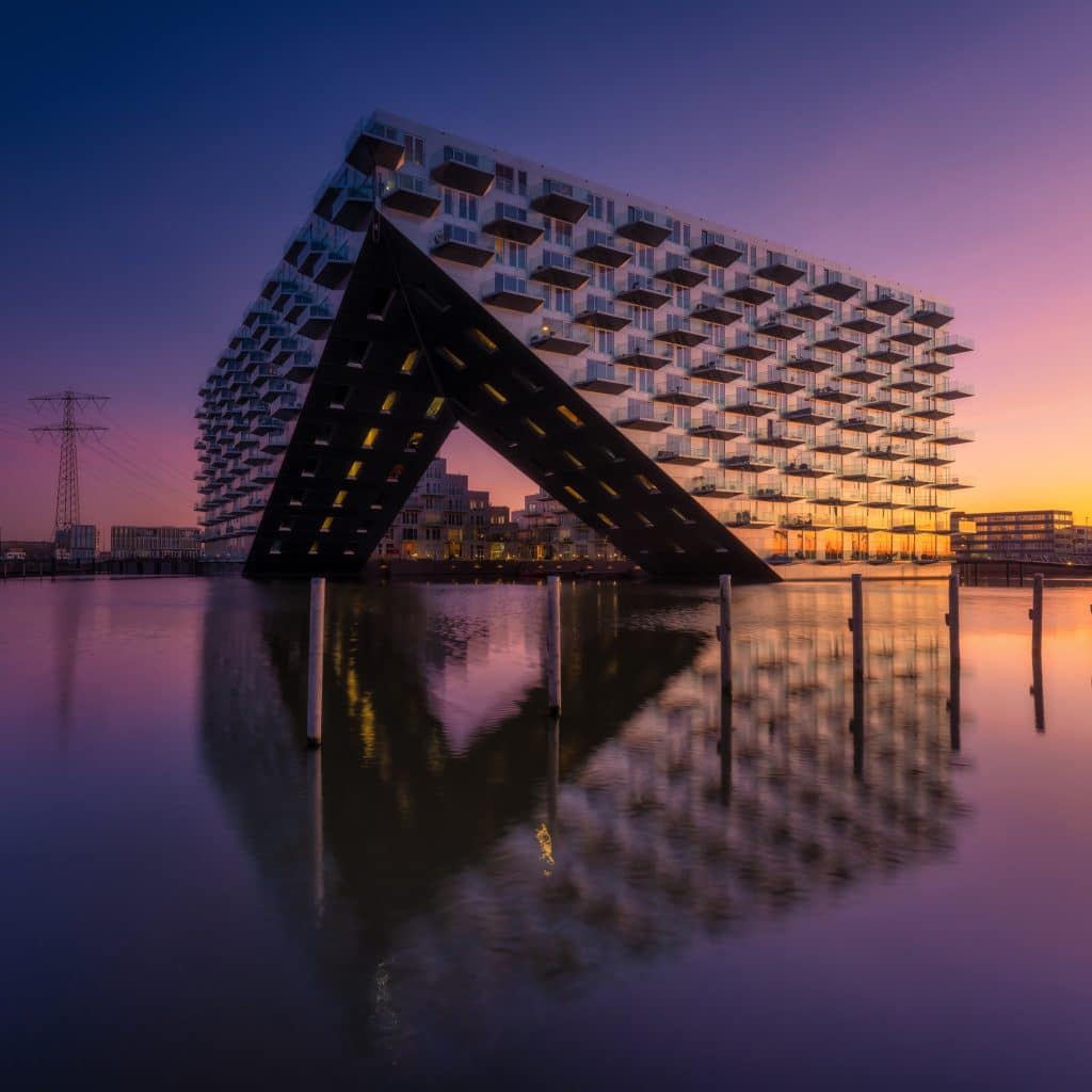 Amsterdam, Netherlands. A cityscape during sunset. A apartment building near the water in the bay.